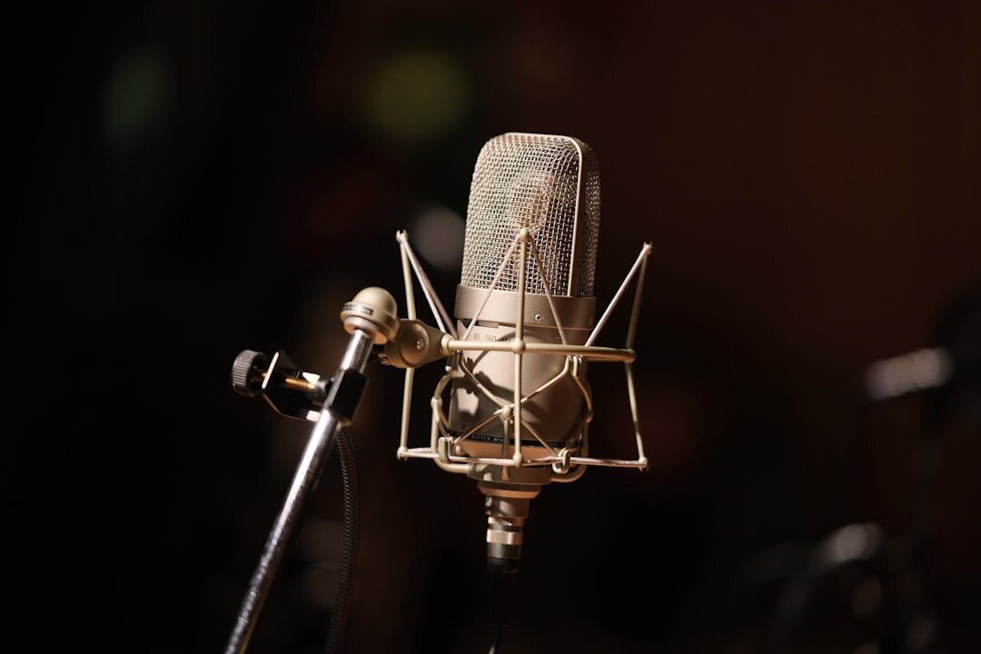 Dark moody recording studio with a microphone under warm light